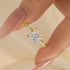 Yellow Gold Princess Cut Ring Held Between Fingers