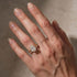 Oval engagement ring with matching band on hand