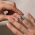 Woman styling a white gold marquise wedding ring set