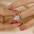 Yellow Gold Oval Cut Wedding Ring Held Between Fingers