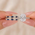 Blue accent cushion cut insert wedding ring set held by hand