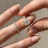 Woman holding a princess cut engagement ring and wedding band