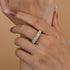Wide round cut eternity wedding band worn on finger