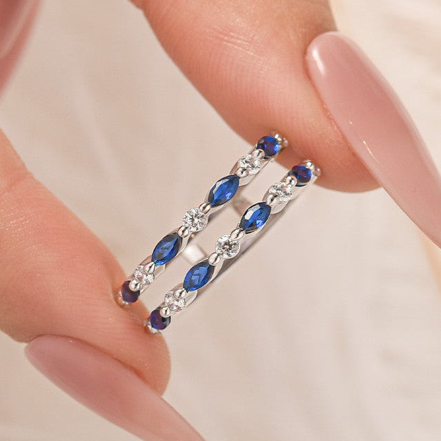 Blue Wedding Ring Enhancer Held Between Fingers