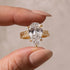 Yellow Gold Pear Cut Travel Ring Held Between Fingers