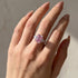 Pink three stone engagement ring worn on hand