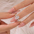Radiant Cut Promise Ring Shown Between Fingers