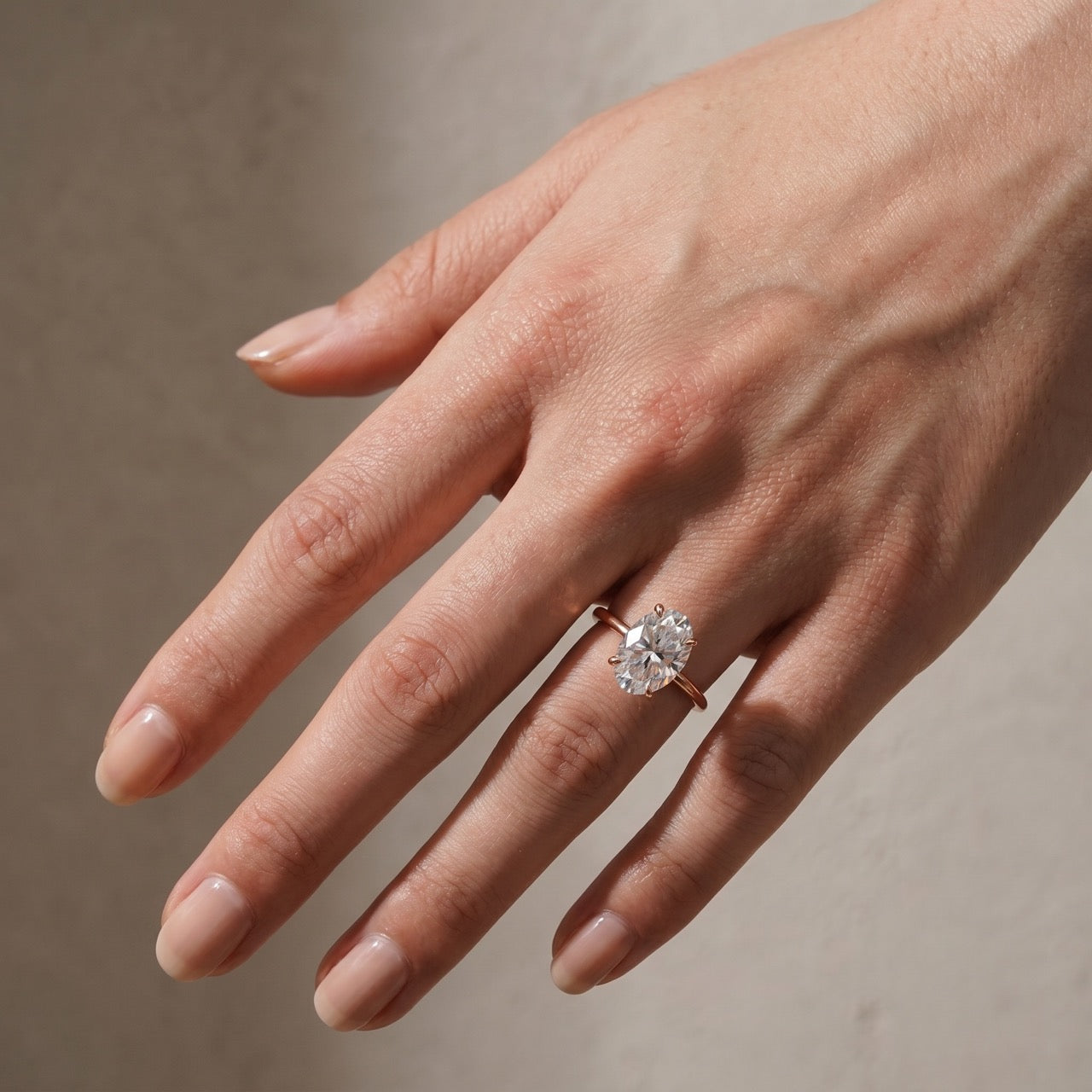 Oval cut engagement ring worn on an elegantly posed hand