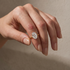 Woman wearing a yellow gold oval cut engagement ring