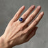 Blue sapphire halo engagement ring worn on hand
