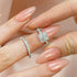 Princess cut engagement ring and wedding band held in fingers