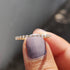 Yellow gold round cut eternity band held in fingers